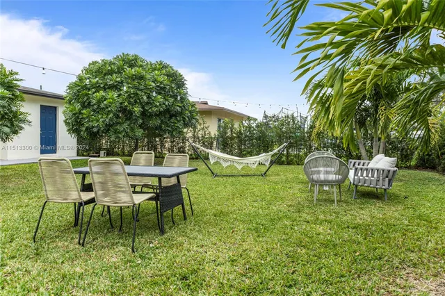 a view of a chairs and table in backyard