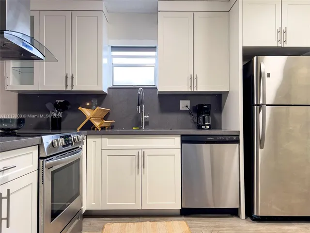 a kitchen with a refrigerator sink and cabinets