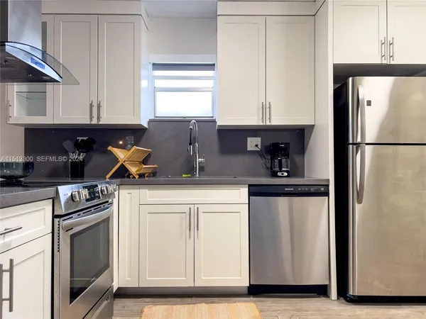 a kitchen with a refrigerator sink and cabinets