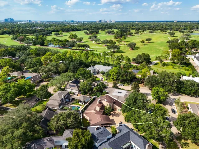 an aerial view of residential houses with outdoor space and trees