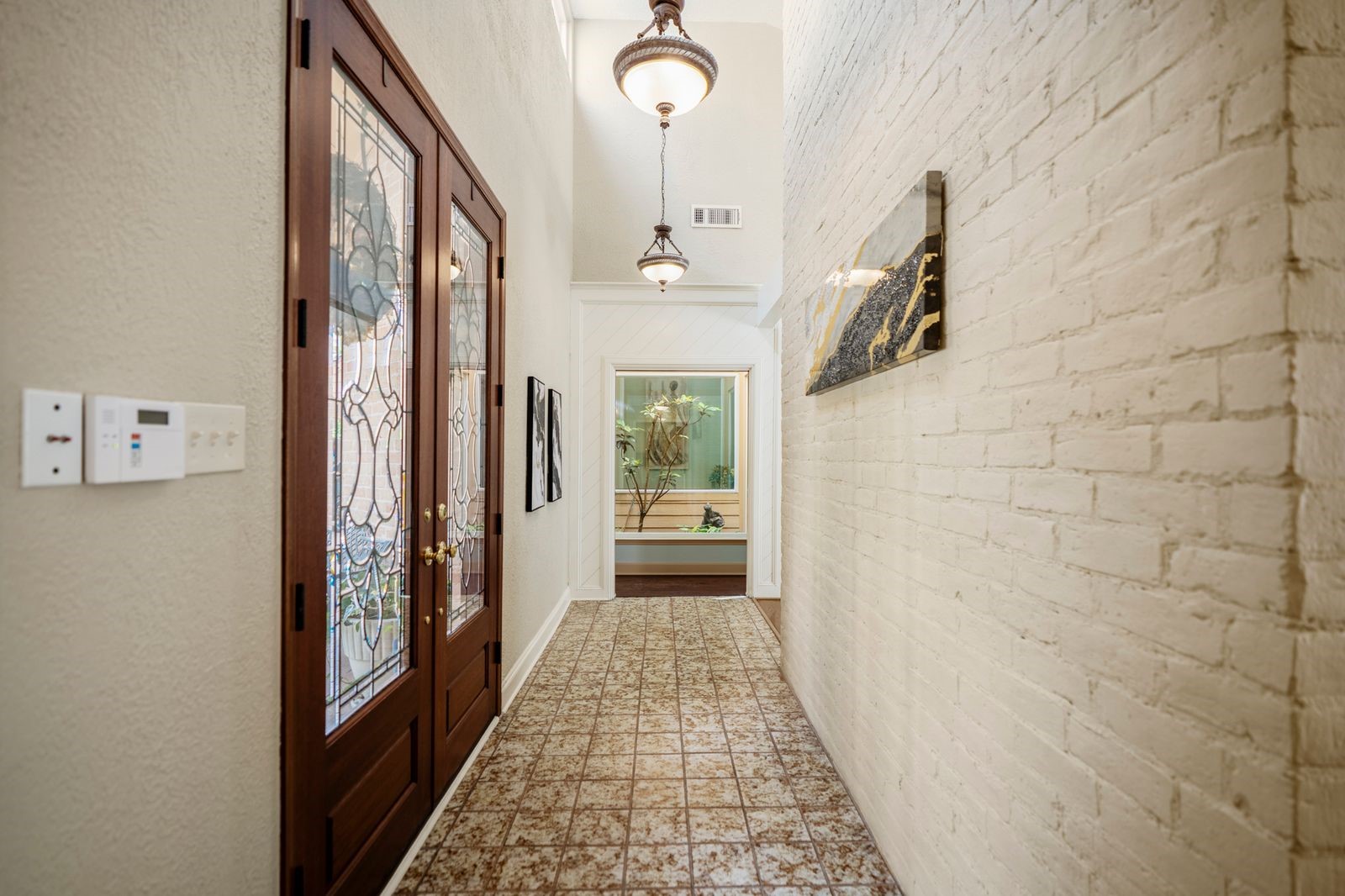 1306 Riverview Court Houston, TX 77077 - Photo 10 of 44 a hallway with a chandelier and a mirror