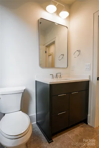 a bathroom with a toilet sink vanity and mirror