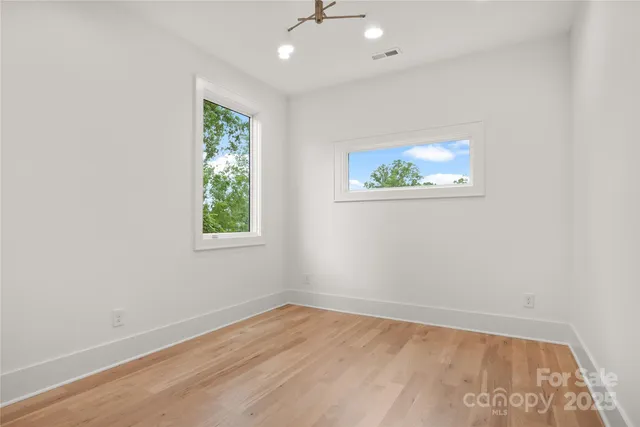 an empty room with a window and a ceiling fan
