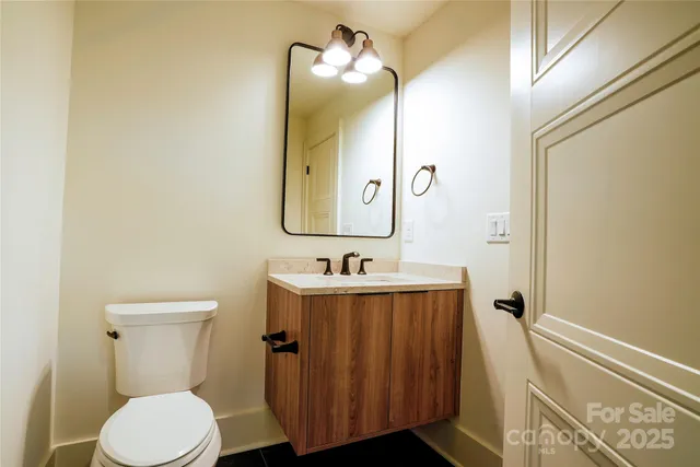 a bathroom with a sink vanity mirror and toilet