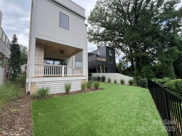 a view of a house with a yard deck and a small yard