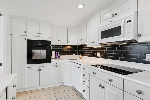 a kitchen with white cabinets and appliances