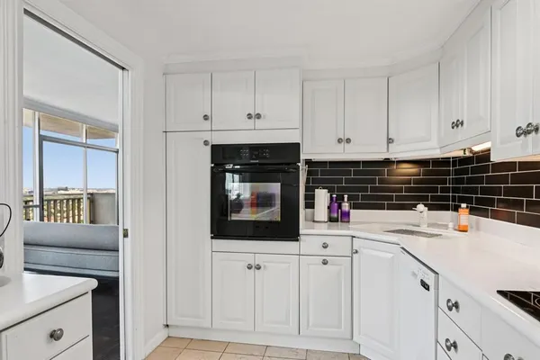 a kitchen with white cabinets and appliances