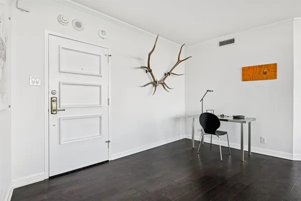 a view of a livingroom with wooden floor closet and windows