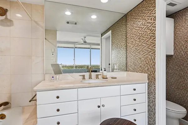 a bathroom with a double vanity sink toilet and a mirror