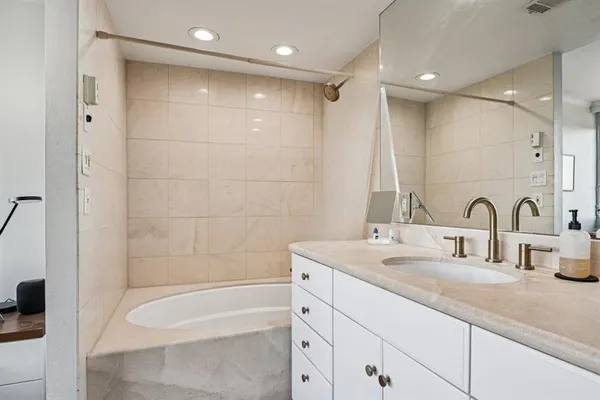 a bathroom with a double vanity sink and a bathtub