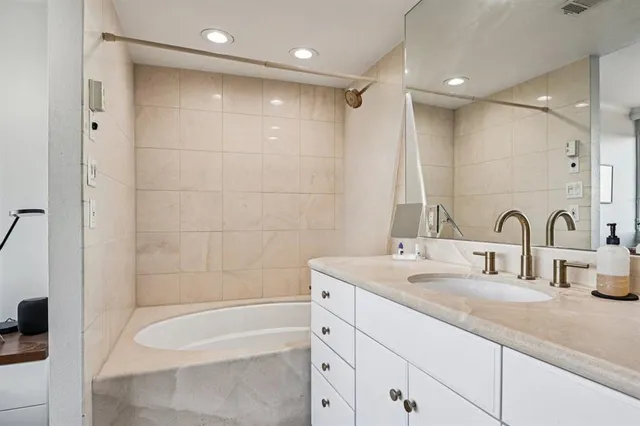 a bathroom with a double vanity sink and a bathtub