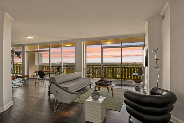 a living room with furniture and a floor to ceiling window