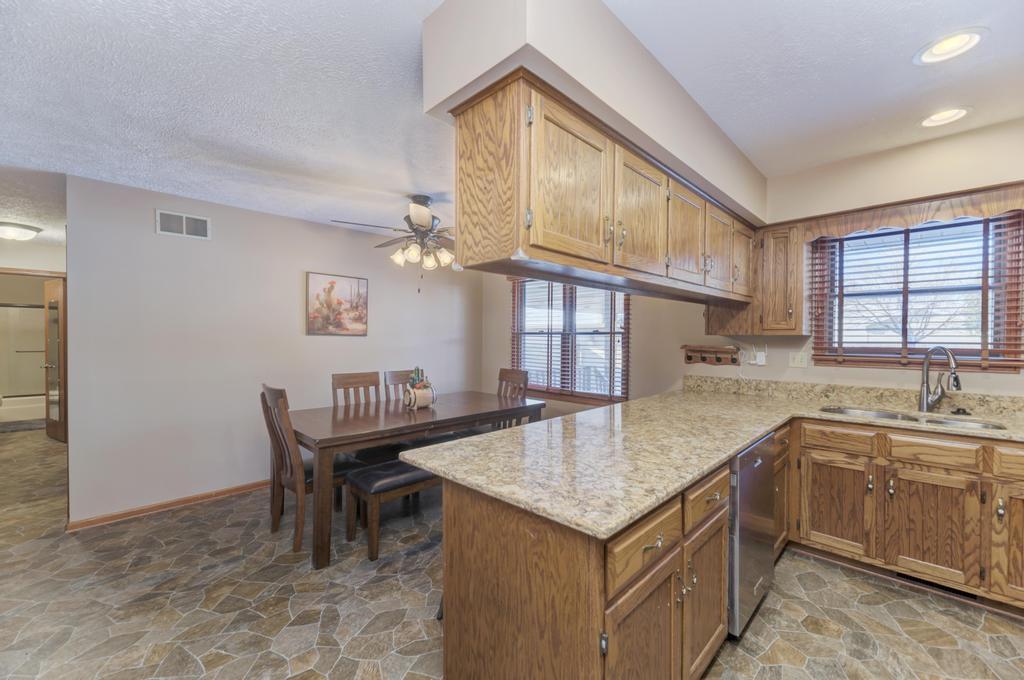 2402 Chestnut Lane Morris, IL 60450 - Photo 13 of 30 a open kitchen with stainless steel appliances granite countertop a sink a stove a dining table and chairs