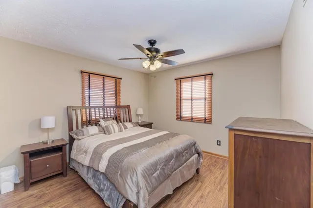 a bedroom with a bed and a ceiling fan