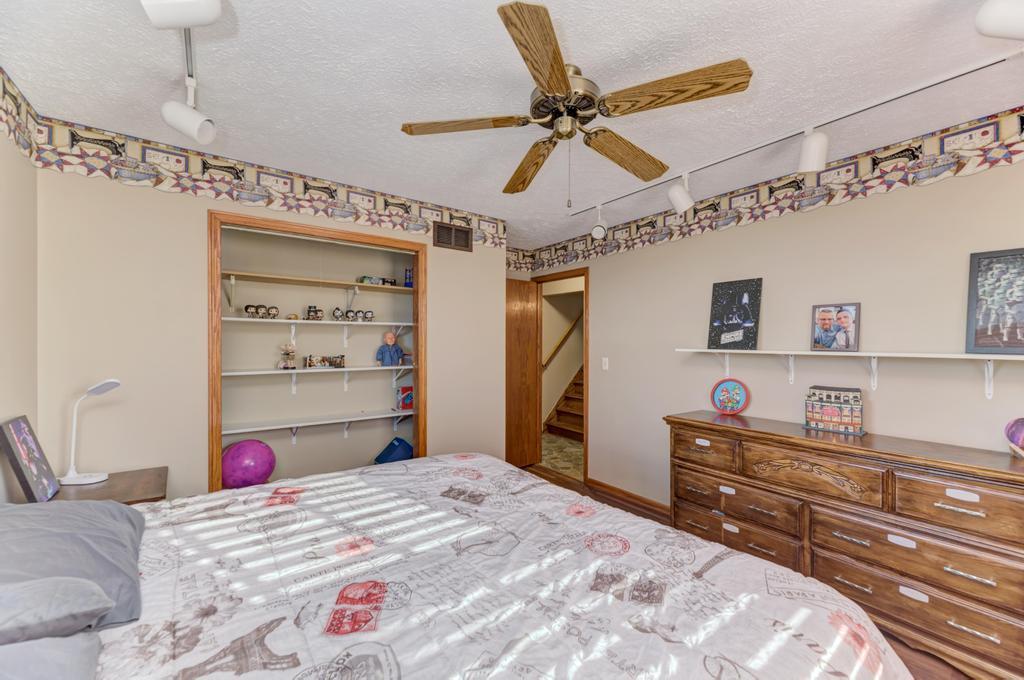 2402 Chestnut Lane Morris, IL 60450 - Photo 20 of 30 a bedroom with a bed and a chandelier