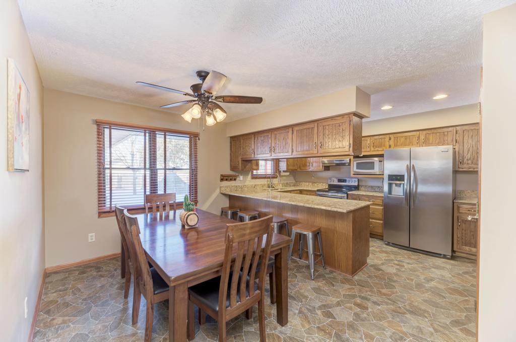 2402 Chestnut Lane Morris, IL 60450 - Photo 7 of 30 a kitchen with stainless steel appliances granite countertop a dining table chairs refrigerator and cabinets