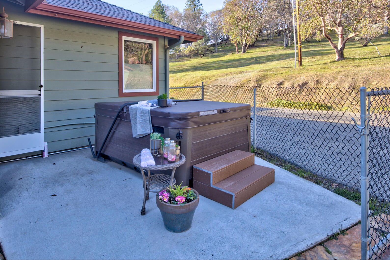 1440 Kubli Road Grants Pass, OR 97527 - Photo 33 of 56 a view of a patio with a table and chairs and floor to ceiling window next to a yard