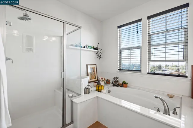 a bathroom with a tub a sink a mirror and a window