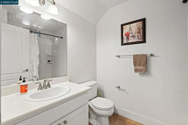 a bathroom with a sink vanity mirror and toilet