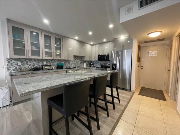 a kitchen with refrigerator and cabinets