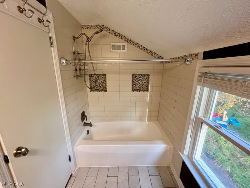 38095 Aurora Road Solon, OH 44139 - Photo 12 of 17 Bathroom with tile floors, a textured ceiling, and tiled shower / bath