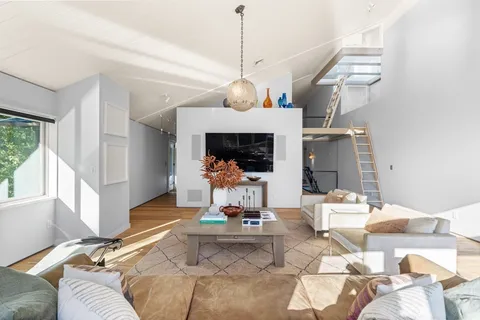 a living room with furniture a fireplace and a chandelier