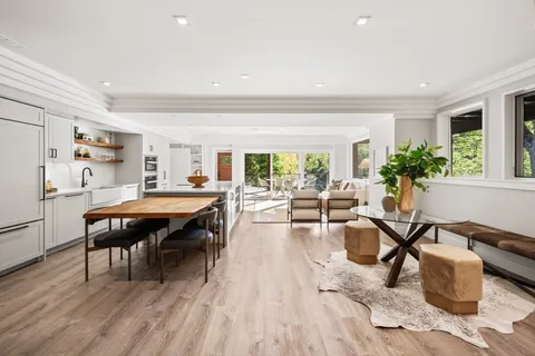 a living room with furniture a dining table and chairs with wooden floor
