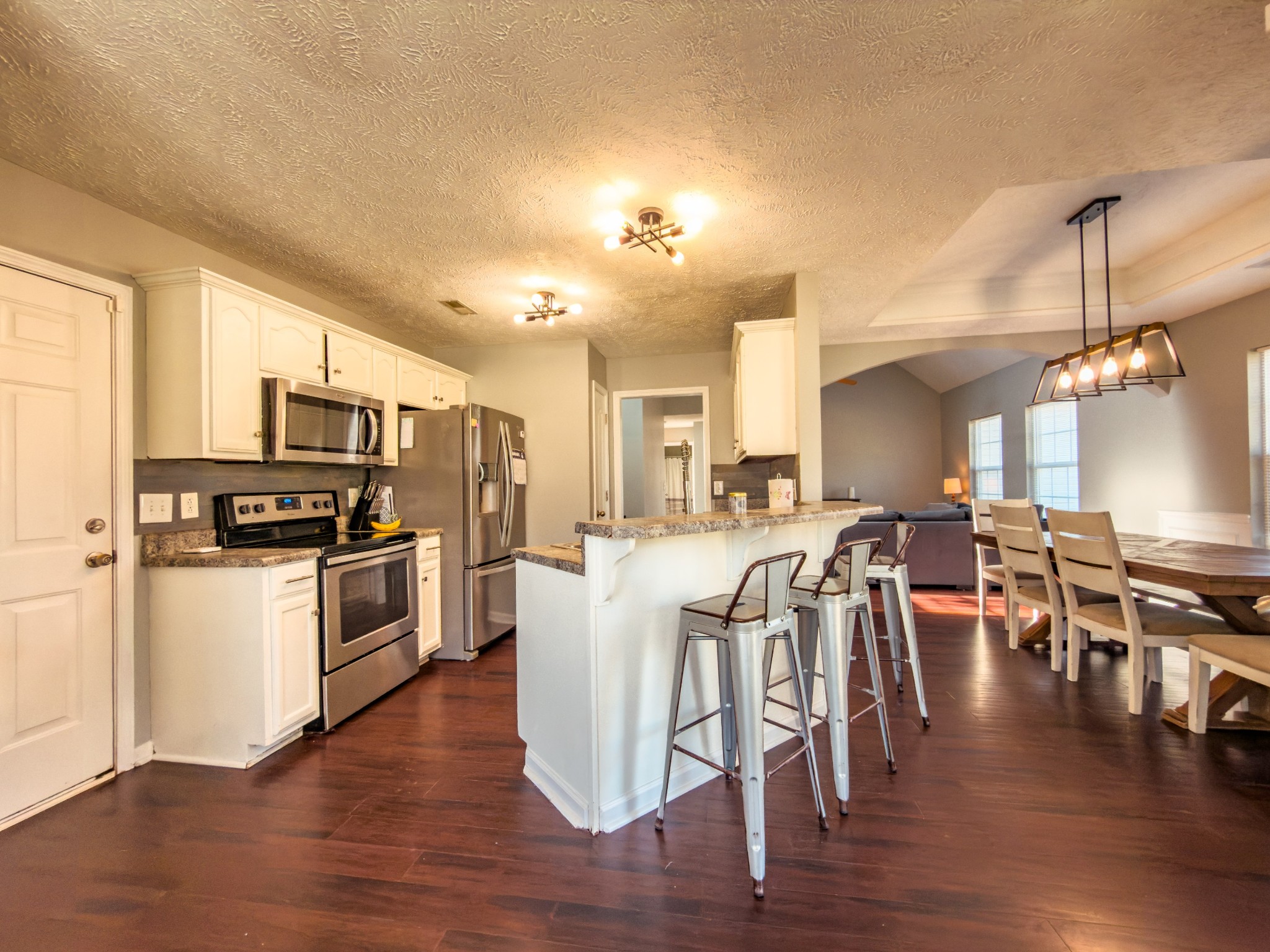 1122 Thompson Farms Street Lascassas, TN 37085 - Photo 6 of 12 a kitchen with stainless steel appliances granite countertop a refrigerator a stove top oven a sink dishwasher a dining table and chairs with wooden floor