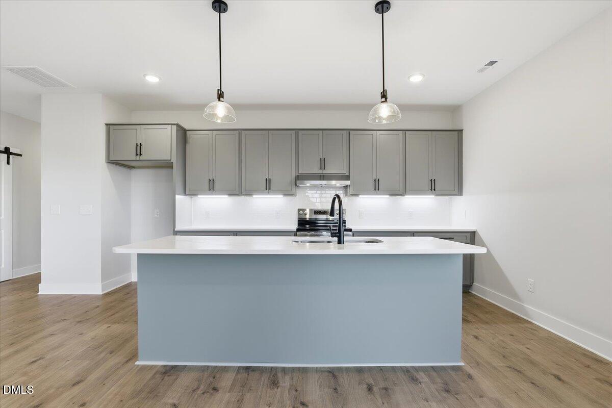 47 Gold Court Kenly, NC 27542 - Photo 12 of 32 a kitchen with stainless steel appliances a sink a window a refrigerator and wooden floor