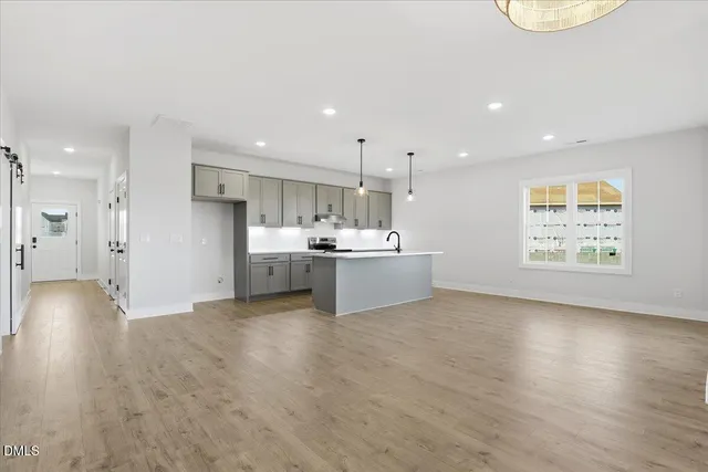 a view of kitchen with kitchen island a sink stainless steel appliances and cabinets
