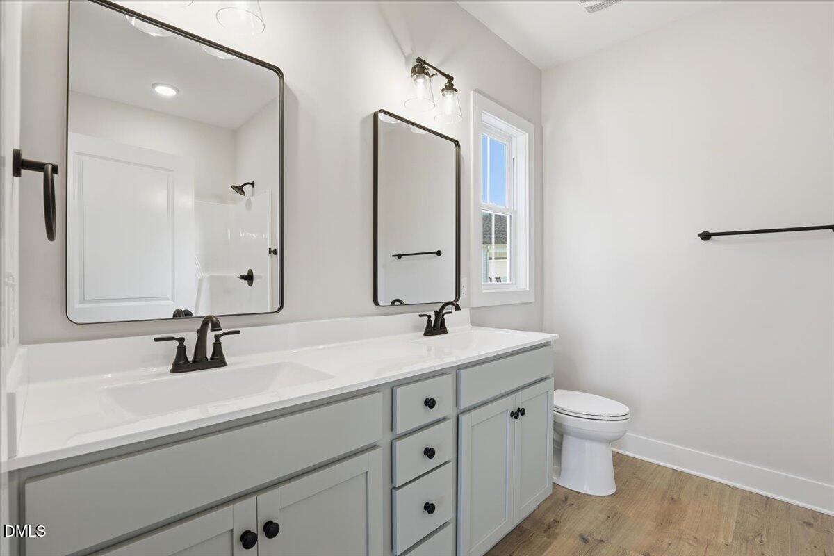 47 Gold Court Kenly, NC 27542 - Photo 19 of 32 a bathroom with a double vanity sink a toilet and a mirror