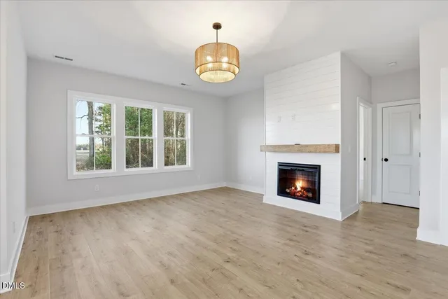 a view of an empty room with a fireplace and a window