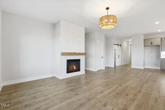 a view of an empty room with a fireplace and a window