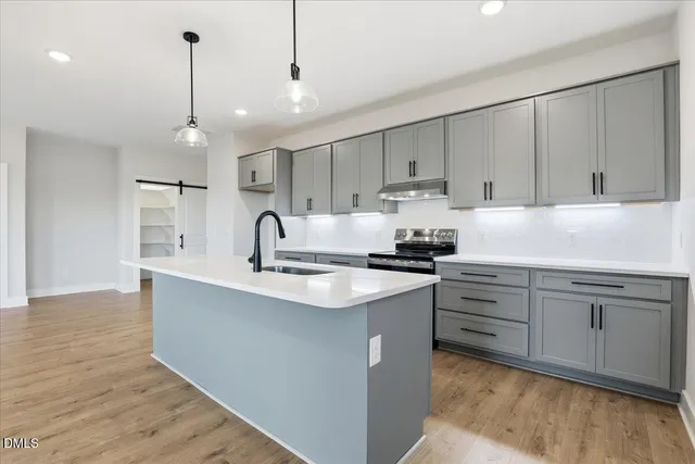 a kitchen with kitchen island a sink stainless steel appliances and cabinets