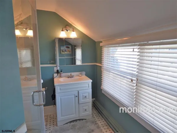 a bathroom with a sink a mirror and next to a window