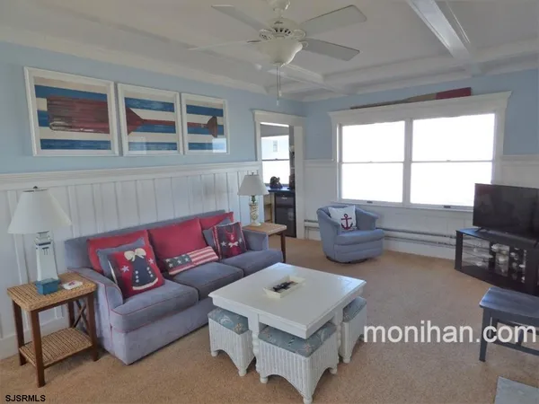 a living room with furniture a flat screen tv and a window