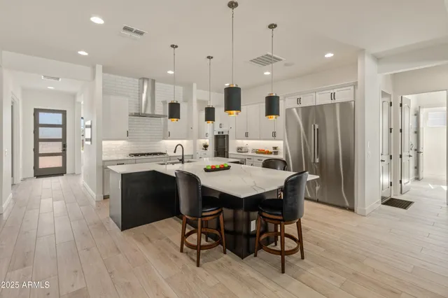 a kitchen with kitchen island granite countertop a sink counter and chairs