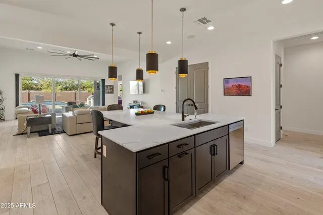 a kitchen with kitchen island stainless steel appliances a sink a stove and a refrigerator