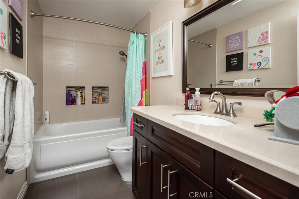 25 Birdsong Irvine, CA 92604 - Photo 20 of 29 a bathroom with a granite countertop sink a toilet a mirror a vanity a bath tub and shower