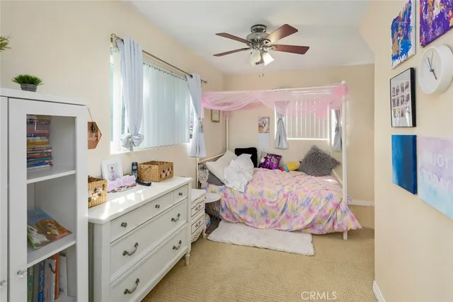 a bedroom with a bed a chandelier and dresser