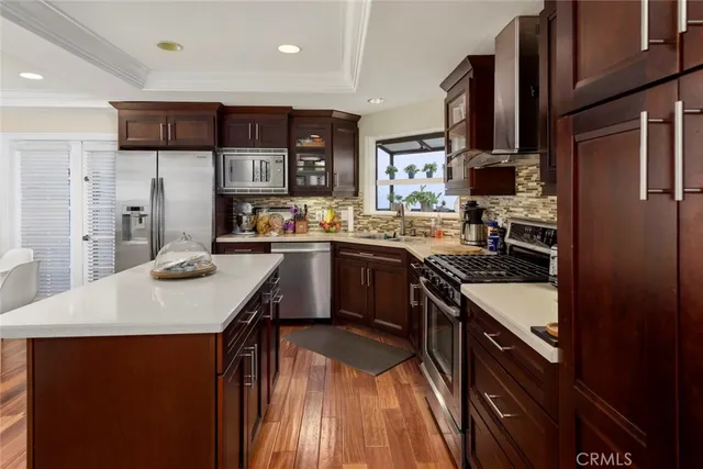 a kitchen with stainless steel appliances granite countertop a sink a stove and a refrigerator