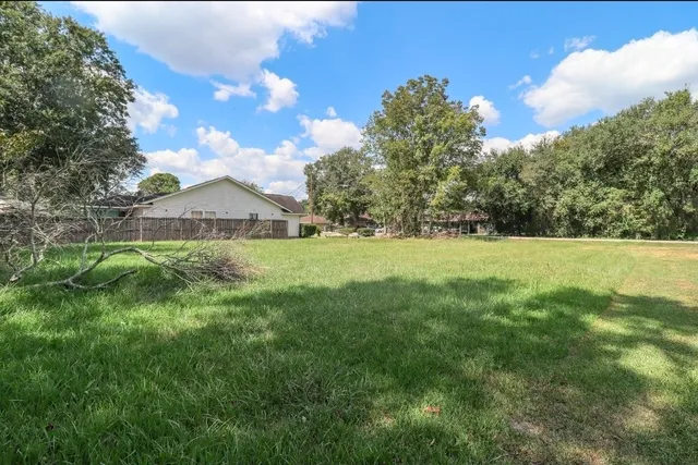 a view of green field with grass and trees