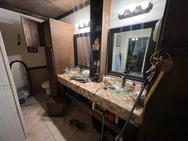 a bathroom with double vanity and a mirror