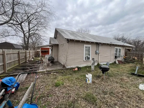 a backyard of a house with yard fire pit and chairs