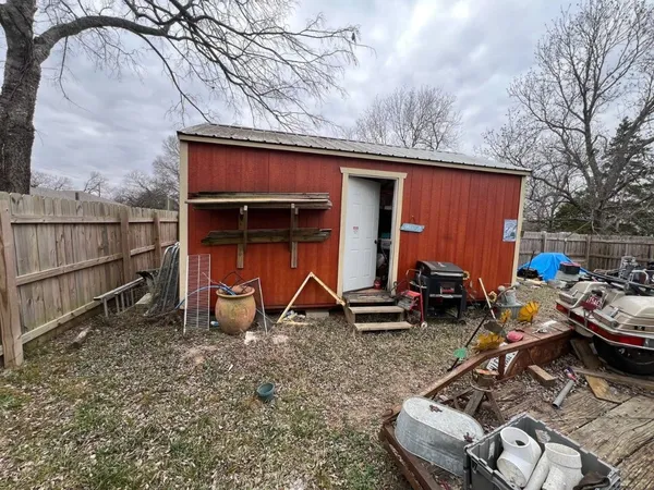 a view of backyard with seating space and wooden fence