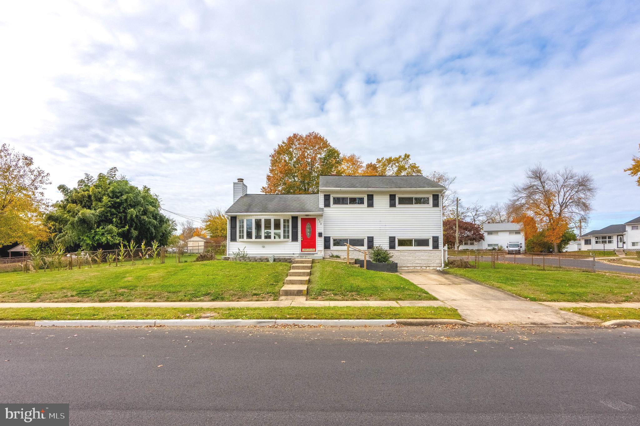 a view of a house with a big yard and large trees