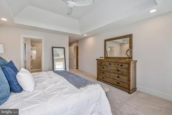 a spacious bedroom with a bed and a dresser