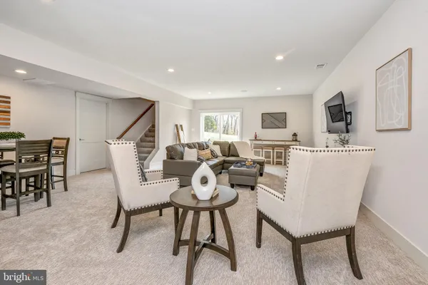 a living room with furniture a flat screen tv and a kitchen view