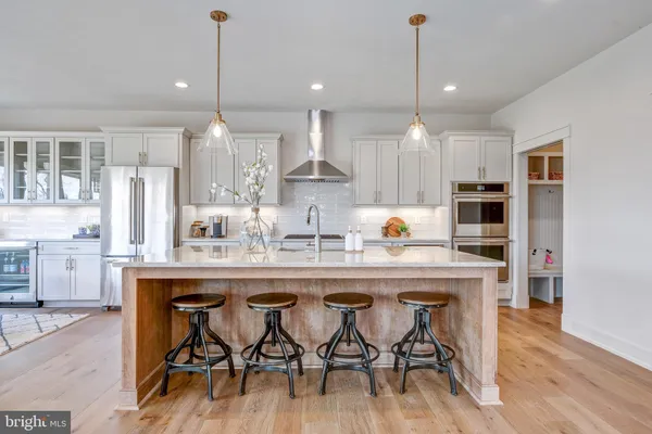 a dining table chairs wooden floor and kitchen view