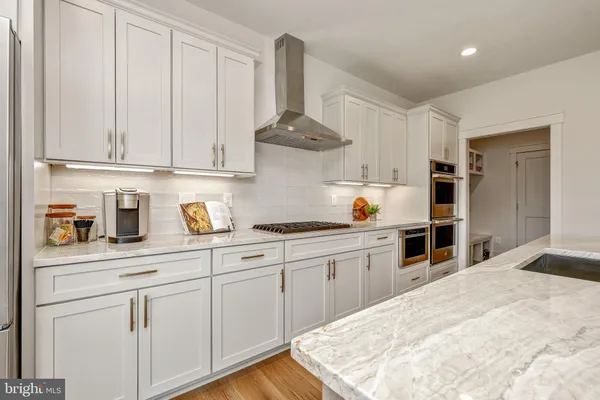 a kitchen with white cabinets and appliances